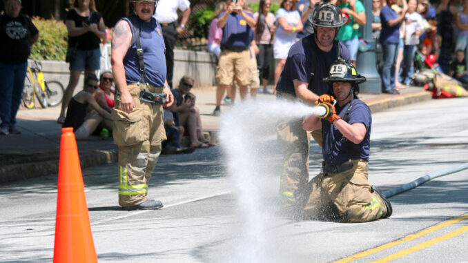 Firefighters participate in a fire rescue competition, known as Musters, during the 2015 Fire on the 4th festival on May 2, 2015, in the Old Fourth Ward section of Atlanta.