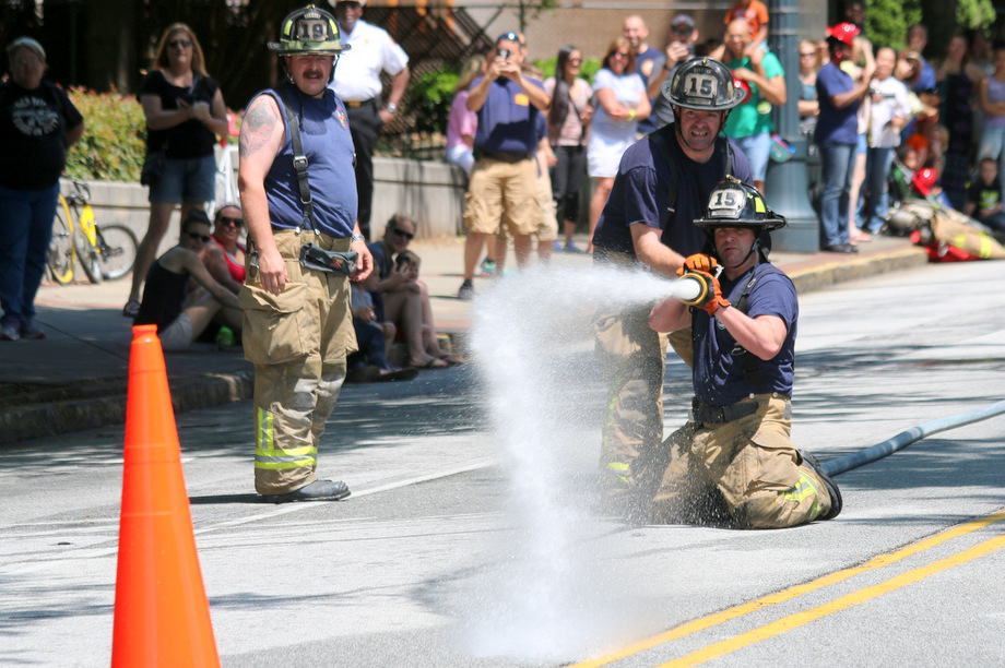 Firefighters participate in a fire rescue competition, known as Musters, during the 2015 Fire on the 4th festival on May 2, 2015, in the Old Fourth Ward section of Atlanta.